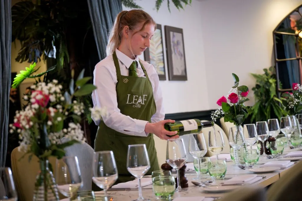 The Castle Hotel Windsor waitress pouring wine leat oak tabe