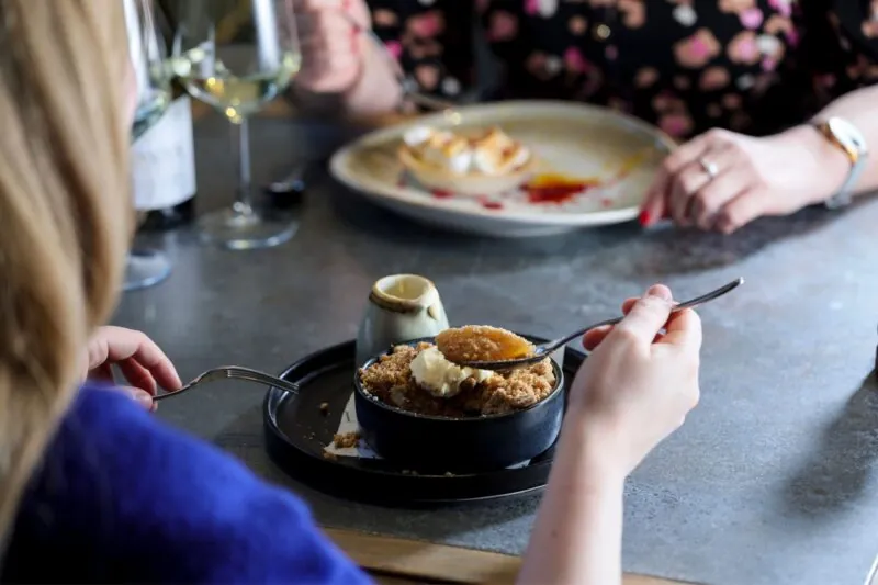 Couple eating apple crumble and lemon meringue tart