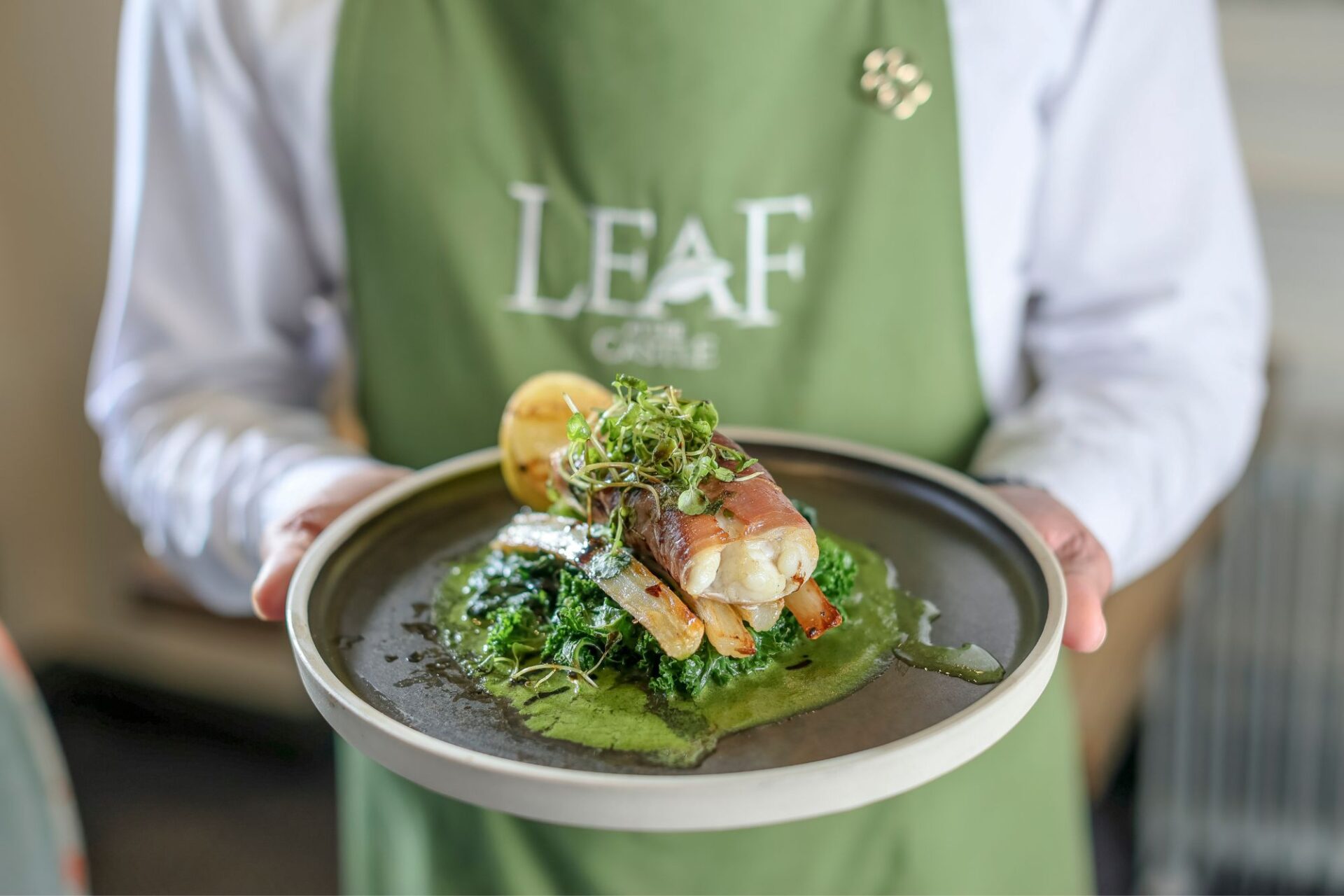 Monkfish tail wrapped with Serrano ham being served