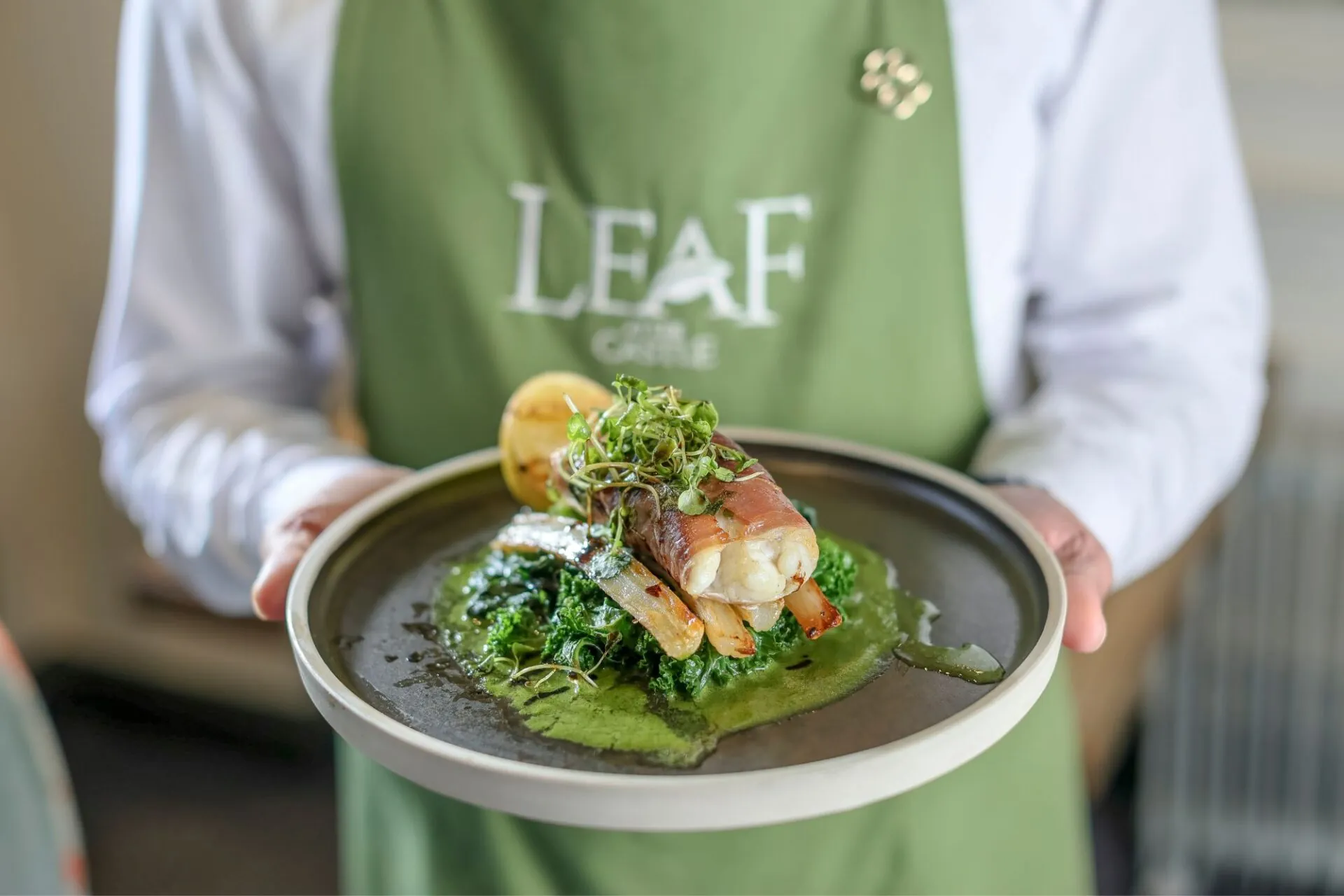 Monkfish tail wrapped with Serrano ham being served